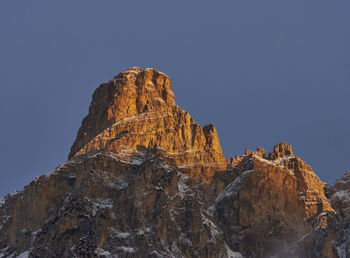 Low angle view of rock formation against sky at sunrise 