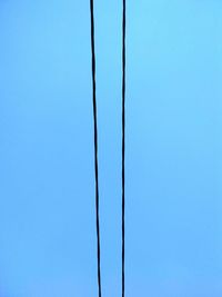 Low angle view of cables against clear blue sky