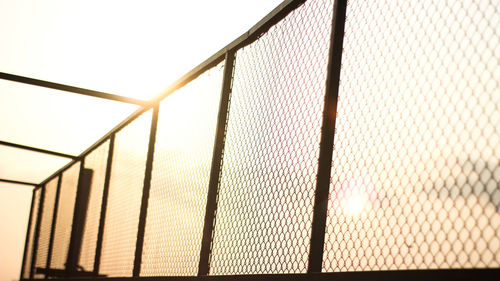 Low angle view of chainlink fence against sky