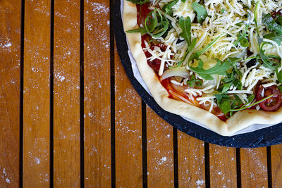 Vegetarian and vegetable pizza on a wooden background.