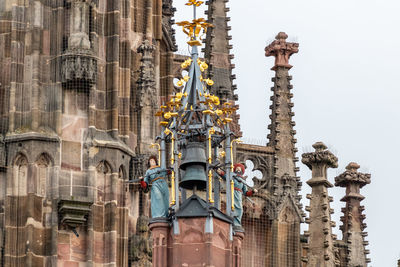Low angle view of sculptures on building against sky