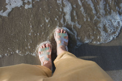 Low section of person relaxing on beach