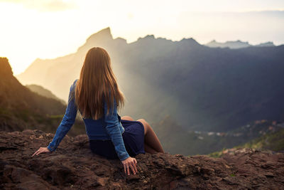 Woman on rock against sky