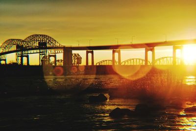 Bridge over river against sky during sunset