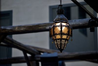 Low angle view of illuminated light bulb against building 