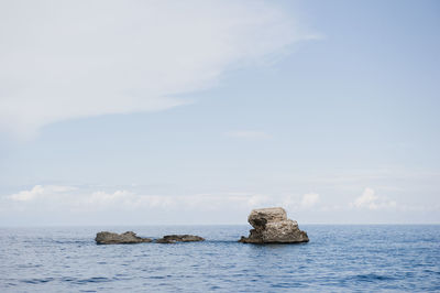 Rocks in sea against sky