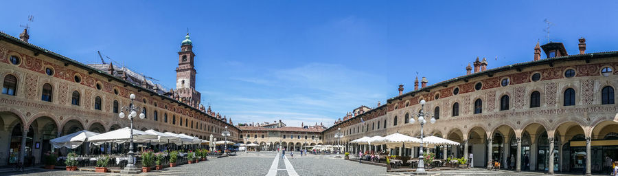 People on street amidst buildings in city