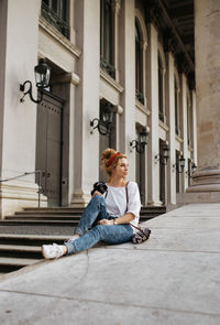 Young woman sitting outside and holding camera