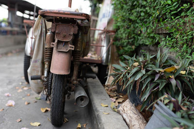 The image of a rusty old motorcycle parked on the side of the road.