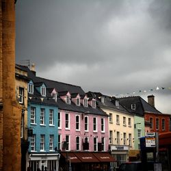 Low angle view of buildings against cloudy sky