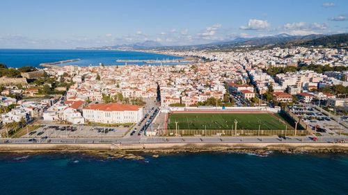 High angle view of townscape by sea against sky