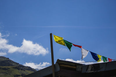 Multi colored flags against blue sky