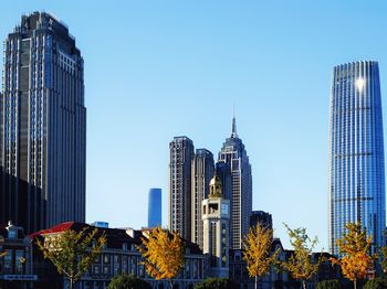 Low angle view of skyscrapers against blue sky