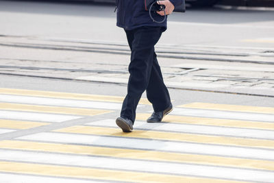 Low section of man crossing road