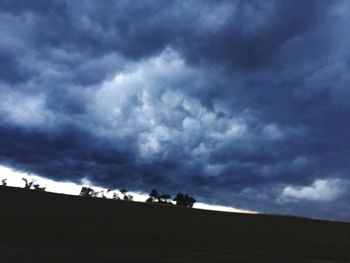 Silhouette landscape against cloudy sky