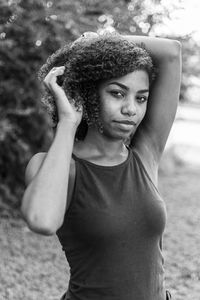 Portrait of young woman against tree