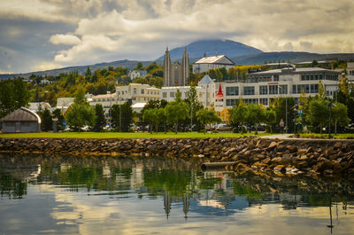 Scenic view of lake by buildings against sky