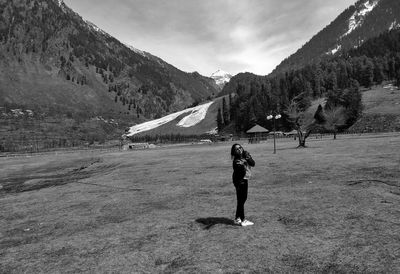 Full length of man standing on field against sky