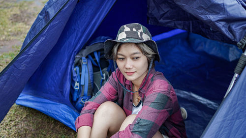 Portrait of a beautiful young woman sitting at tent