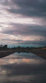 Scenic view of lake against sky at sunset