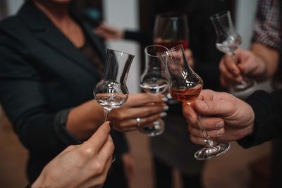 People holding brandy glasses