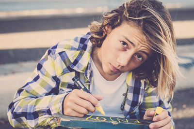 Portrait of boy writing on wood