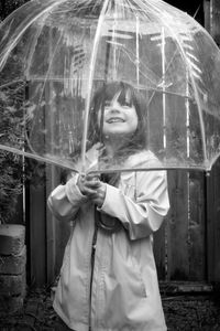 Portrait of a smiling girl standing in rain