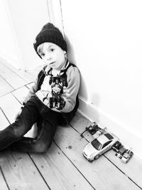 Portrait of cute boy sitting on floor at home