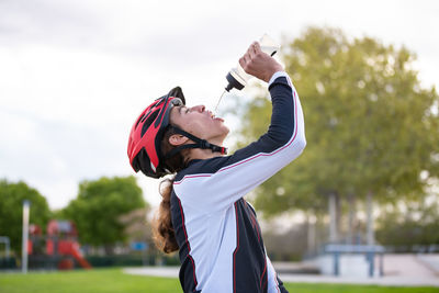 Side view of male athlete drinking water