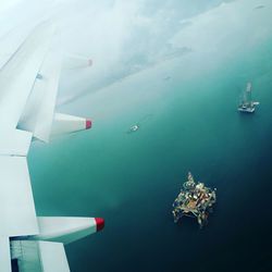 Airplane flying over sea against sky