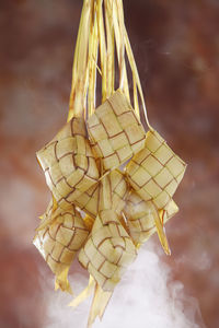 Close-up of ketupats hanging indoors