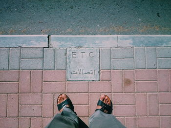 Low section of man standing on sidewalk