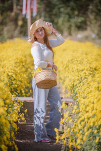 Portrait of a smiling young woman with yellow flower