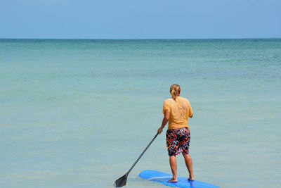 Rear view of man standing on beach