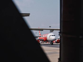 Airplane on airport runway seen through window