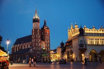 Group of people in front of building against blue sky