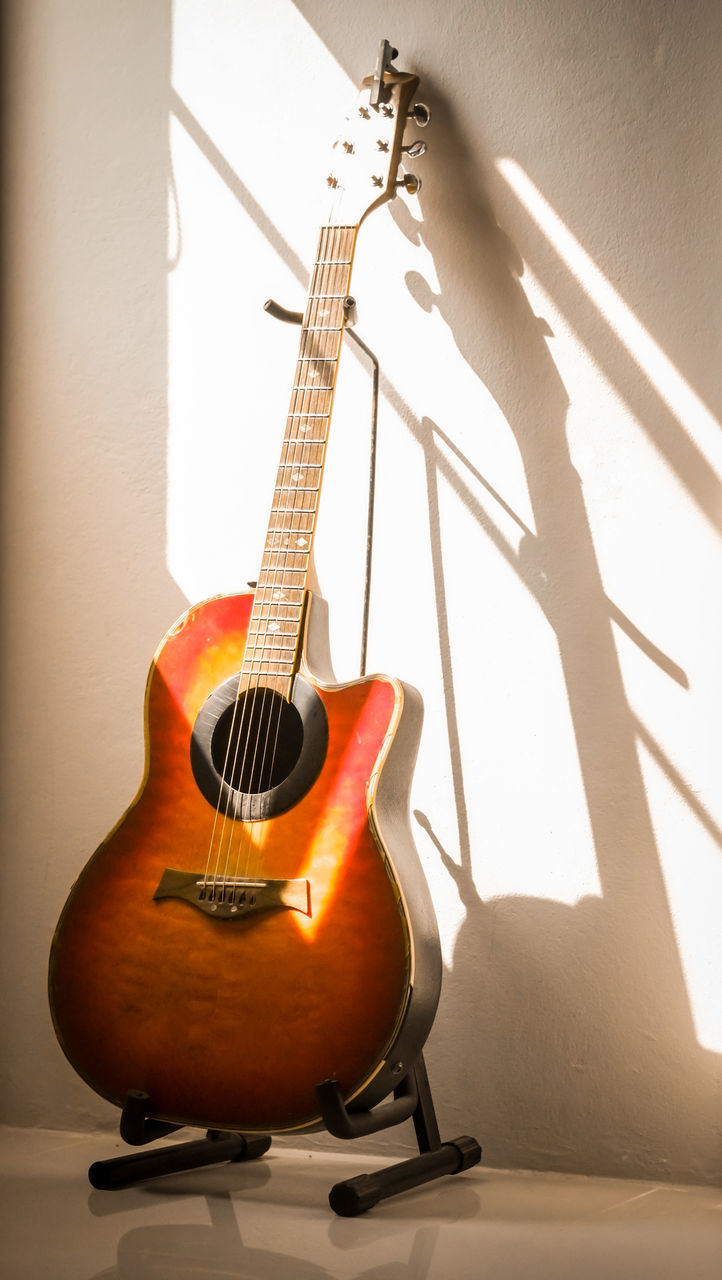 CLOSE-UP OF GUITAR ON WALL