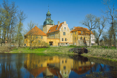 Reflection of trees and buildings on lake