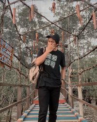 Young man standing on footbridge