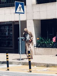 Full length of young woman standing against built structure