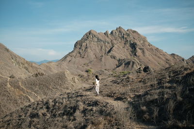 Man walking on mountain against sky