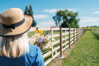 Countryside getaways, country vacations, farm stays. young woman in straw hat enjoys summer