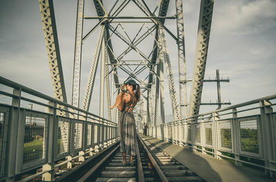 Low angle view of woman standing on bridge