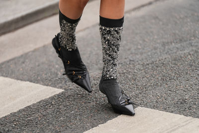 Low section of woman standing on road