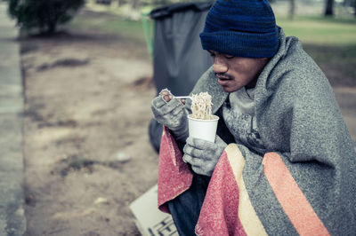 Midsection of man holding ice cream outdoors