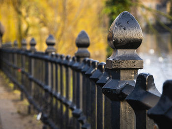 Close-up of metal railing by fence