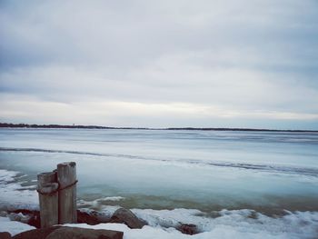 Scenic view of snow covered sea against sky