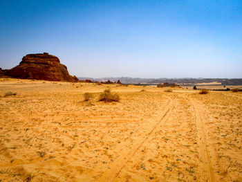 Scenic view of desert against clear blue sky