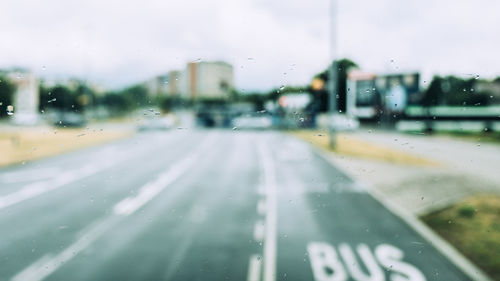 Road seen through wet glass window