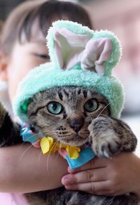 Close-up portrait of cat being held by girl